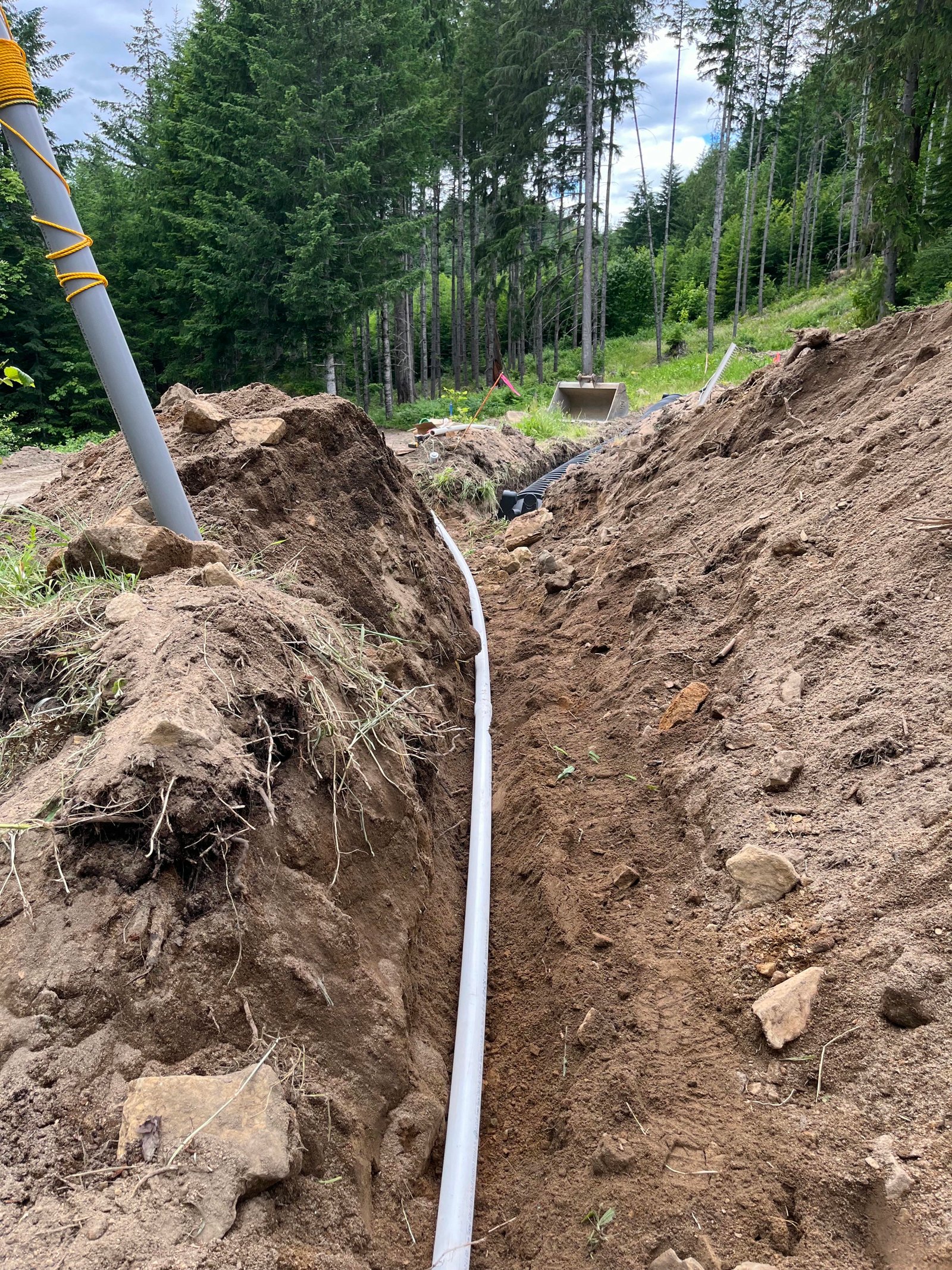 PVC utility pipe laid in a clean trench for water and power hookups during home site preparation